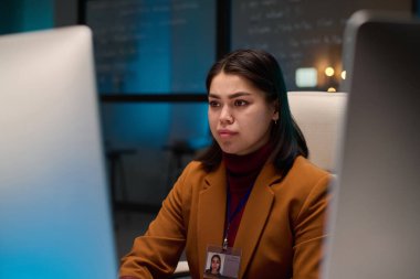 Siber güvenlik departmanında çalışırken ekrana bakan genç bir bilgisayar programcısının portresi