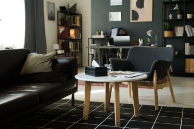 Kitaplıkları, modern masası ve sandalyeleri olan küçük bir ofis odası olan rahat bir oturma odası. Tarafsız tonlu mobilyalar aşırı resmi olmadan sıcak, davetkar bir atmosfer yaratır.