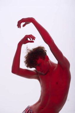 Çok ırklı bir adam kollarını kaldırarak etkileyici bir dans hareketi yapıyor, sağlam bir arka plana karşı hareket halinde çekilip fotokopi alanı sağlıyor. Bir an dalmış gibi görünüyor.