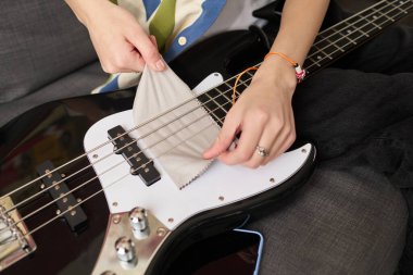 Gitarın daha iyi ses kalitesi ve uzun ömrü için düzgün ve düzgün çalışan bir enstrüman için telleri ve parçaları nazikçe silerek elektro gitarın korunması