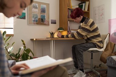 Yurt odasındaki fotokopi odasında oturmuş, ödevlerini yapan ve ders çalışan...