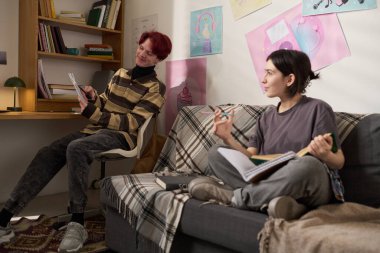 Üniversite yurdunda birlikte okurken arkadaşlarıyla iletişim kuran genç kız portresi.