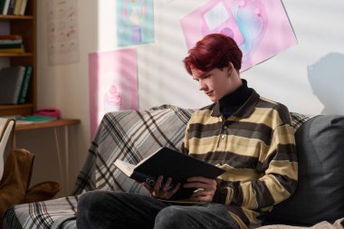 Kitap okurken gülümseyen ya da kanepede oturup fotokopi çeken bir çocuğun hayali yan görüntüsü.