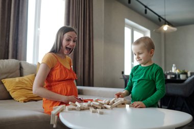 Anne ve oğlunun tahta bloklarla oynarken çekilmiş gizli bir fotoğrafı. İkisi de şaşırmış ve heyacanlı görünüyor.