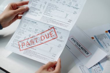 Geçmişteki mali belgeleri gözden geçirirken elinde fatura tutan tanınmayan bir kadının üst görüntüsü.