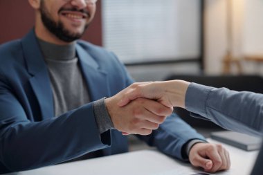 Tanımlanamayan iş adamının iş yerinde fotokopi alanının üzerinde kadın iş arkadaşı veya partnerle tokalaşması.