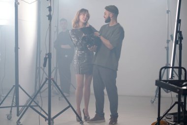 Film ekibinin oyuncu ve yönetmenle geniş açılı çekimi klip setinde inceleniyor.