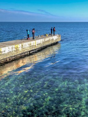 Odessa, Ukrayna 28.10.2022. Ukrayna 'nın Odessa kentindeki Lanzheron rıhtımında güneşli bir sonbahar gününde balıkçılar.