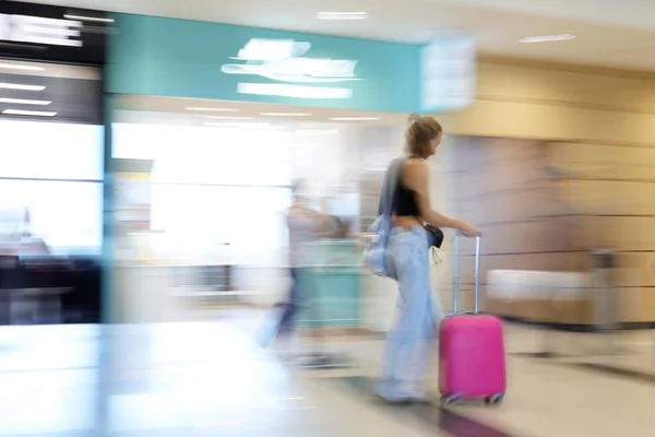 一个带着手提箱的模糊的旅行女人 — 图库照片