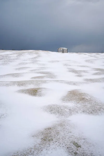 寒い冬の日に曇りの空に対して白い雪で覆われた平野に位置する遠くのアパートの建物 — ストック写真