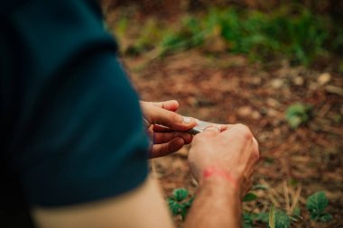 Ormanda marihuana saran bir adamın yakın çekimi.