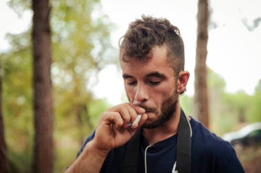 Ormanda marihuana içen bir adamın yakın çekimi.