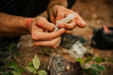 Ormanda marihuana saran bir elin yakın çekimi.