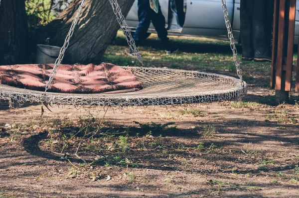 Round hammock with blanket for relaxing on tree near car