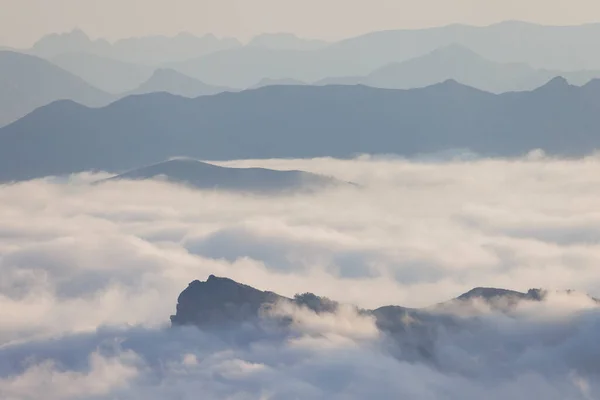 stock image rocky mountain ridges at sunset with fog