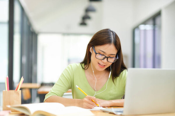 Young asian woman student study at home using laptop and learning online. Business freelancer video conference through laptop at home.