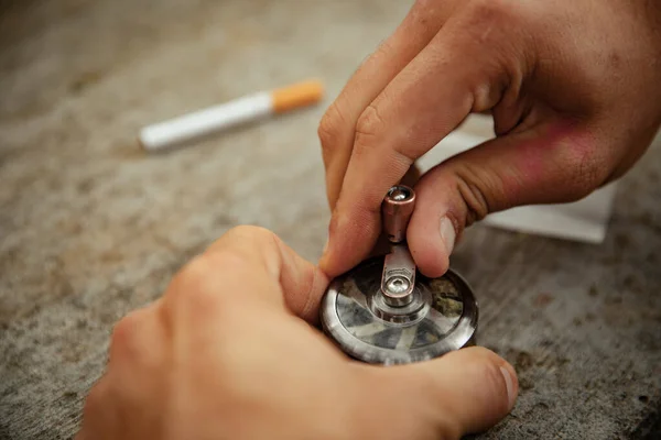 一个人的手在用磨床准备大麻 — 图库照片