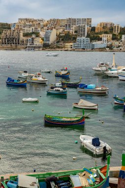 St. Paul Körfezi 'ndeki balıkçı tekneleri ve turist gemileri Bugibba, Malta