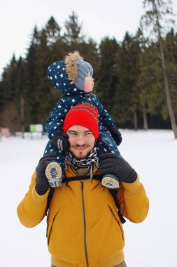 Babalar omuzlarında oturan çocuk