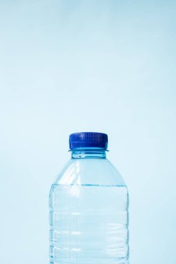 Mavi arka planda plastik su şişesi