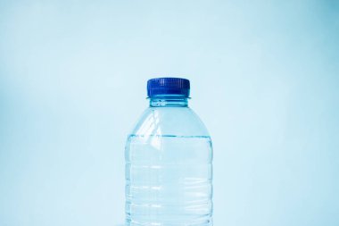 Mavi arka planda plastik su şişesi