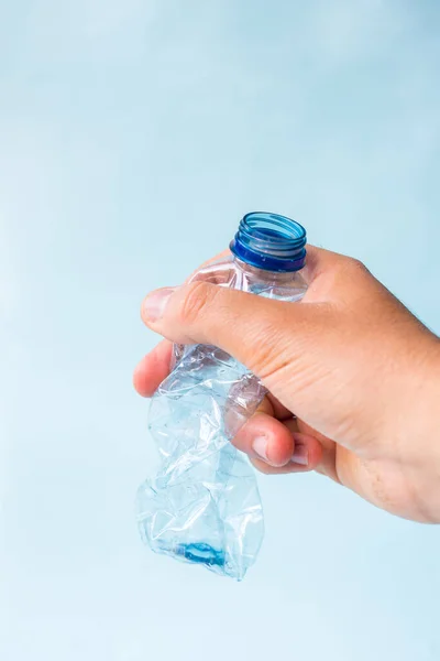 Mano Tomando Botella Plástico Despojado Sobre Fondo Azul —  Fotos de Stock
