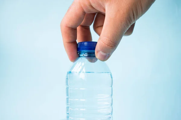 Χέρι Λαμβάνοντας Πλαστικό Μπουκάλι Νερό Μπλε Φόντο — Φωτογραφία Αρχείου