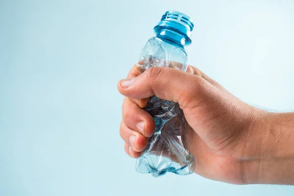 Pelar Mano Una Botella Plástico Sobre Fondo Azul —  Fotos de Stock
