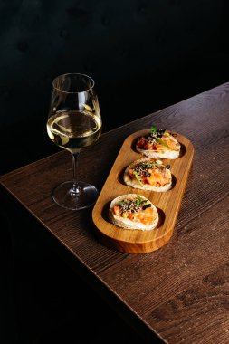 Balık aperatifi tost ve bardakta beyaz şarap.
