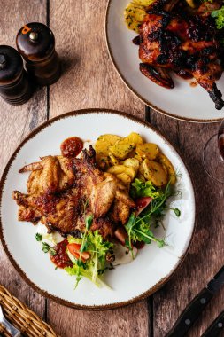 Sebze ve otlarla servis edilmiş soslu ızgara bıldırcın.