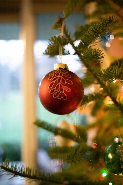挂在圣诞树上的单个圣诞装饰品的垂直图像 — 图库照片