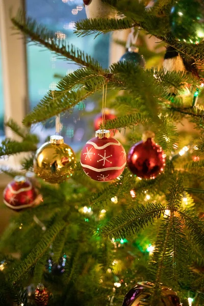 挂在圣诞树上的圣诞装饰品的垂直图像 — 图库照片