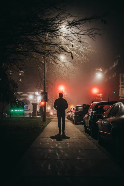 Άνθρωπος Περπατά Μόνος Ένα Πεζοδρόμιο Της Πόλης Μια Ομιχλώδη Νύχτα — Φωτογραφία Αρχείου