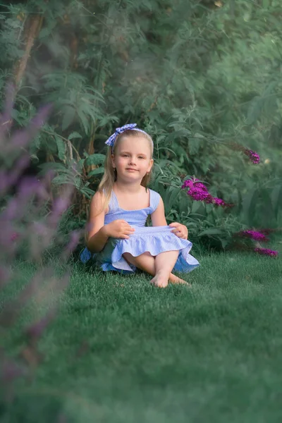 花の間の草原に座っている女の子 — ストック写真