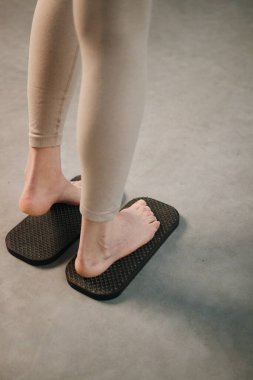 Keskin metal çivilerle tahta tahtada duran kadın sadhu yoga tahtası.