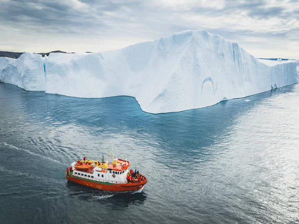 空中から見ると大きな氷山の近くにある小さな船は — ストック写真