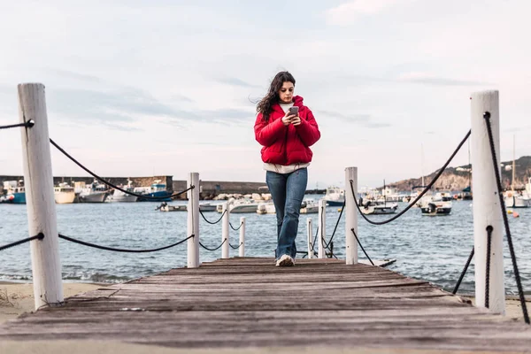 海の前の木製の桟橋を歩く女性は — ストック写真