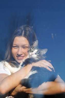 Güneşli havada genç bir kız pencereye yansıtılır. Psikoloji