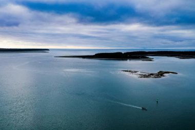Mavi suları ve gökyüzüyle okyanus körfezinden geçiyor.