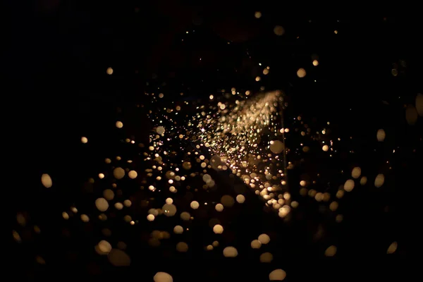 Sparks in dark. Stream of lights on black background. Metal crushing. High temperature. Steel particles fly.