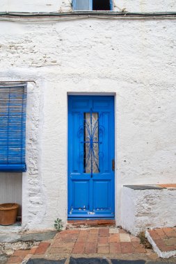 A blue door in a white wall in Cadaqus (Catalonia) 