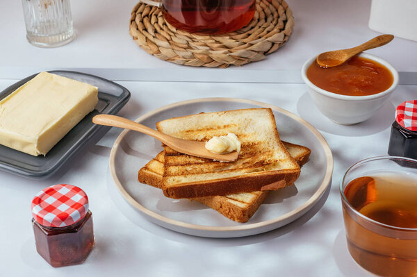 toast with butter on a plate and tea in a cup