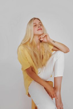 Çilli ve uzun saçlı doğal sarışın kadın portresi. Kız kameraya bakıyor.