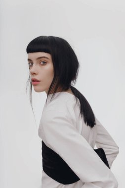 Güzel esmer genç esmer kadın neşeyle gülümseyerek, kamera için beyaz dişlerini gün kapalı gösteren ilk mutlu ve kaygısız ona hissederken tüylü saç modeli ile kapalı portresi