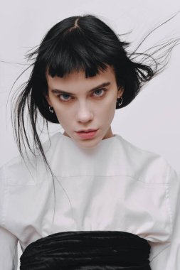 Güzel esmer genç esmer kadın neşeyle gülümseyerek, kamera için beyaz dişlerini gün kapalı gösteren ilk mutlu ve kaygısız ona hissederken tüylü saç modeli ile kapalı portresi