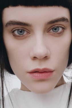 Güzel esmer genç esmer kadın neşeyle gülümseyerek, kamera için beyaz dişlerini gün kapalı gösteren ilk mutlu ve kaygısız ona hissederken tüylü saç modeli ile kapalı portresi