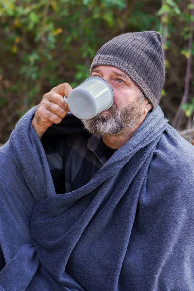 man on a camping trip having a cup of coffee