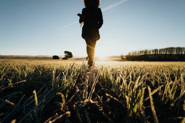 person walking through the field at dawn