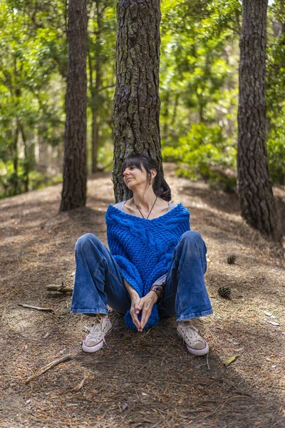 Portrait of a woman sitting on the floor in the woods