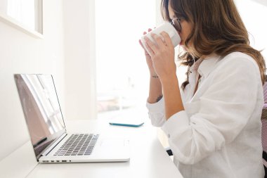 Woman Working from Home Office Holding a Mug Drinking Coffee